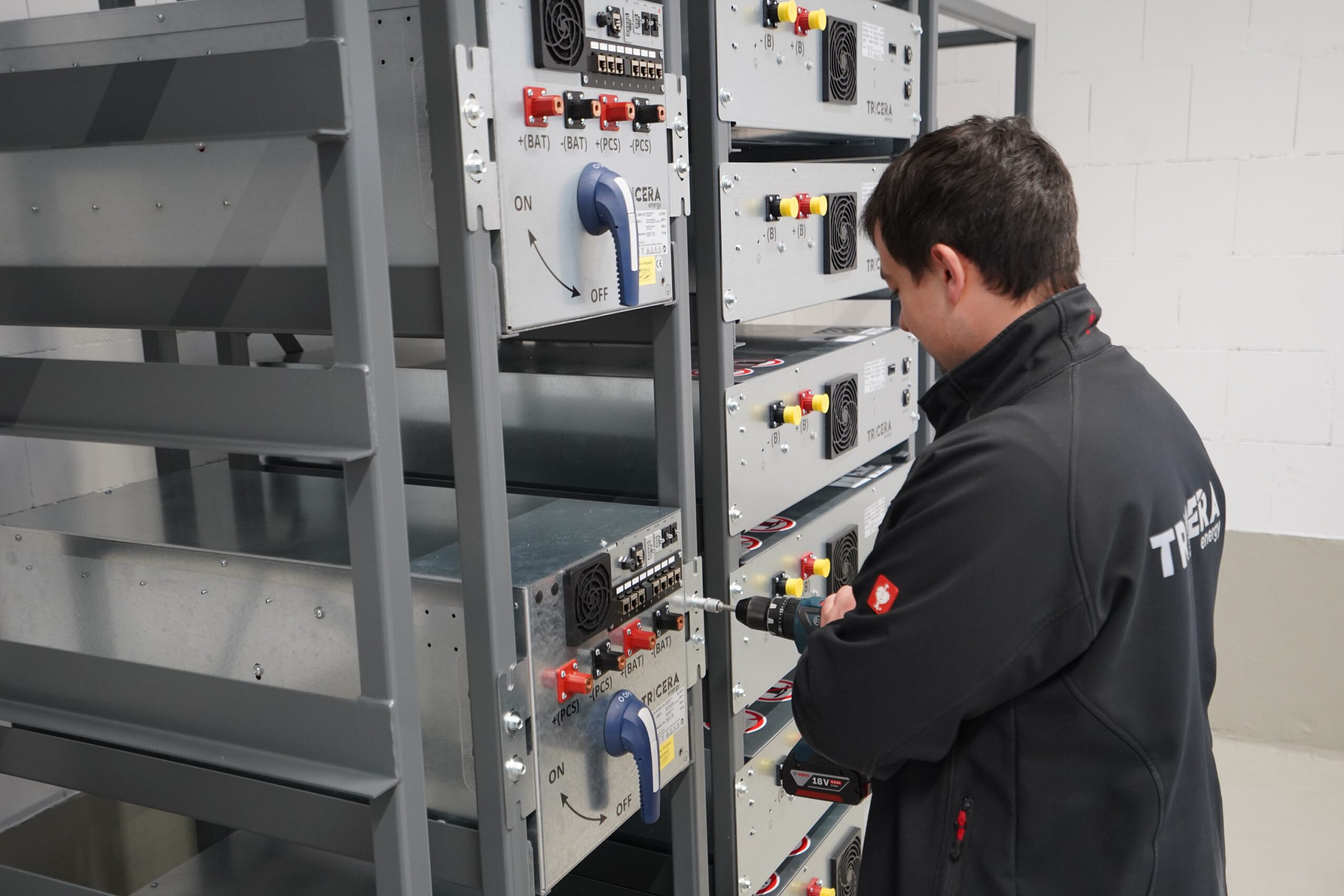 Mitarbeiter arbeitet an der Fertigstellung eines Indoor-Batteriespeichers